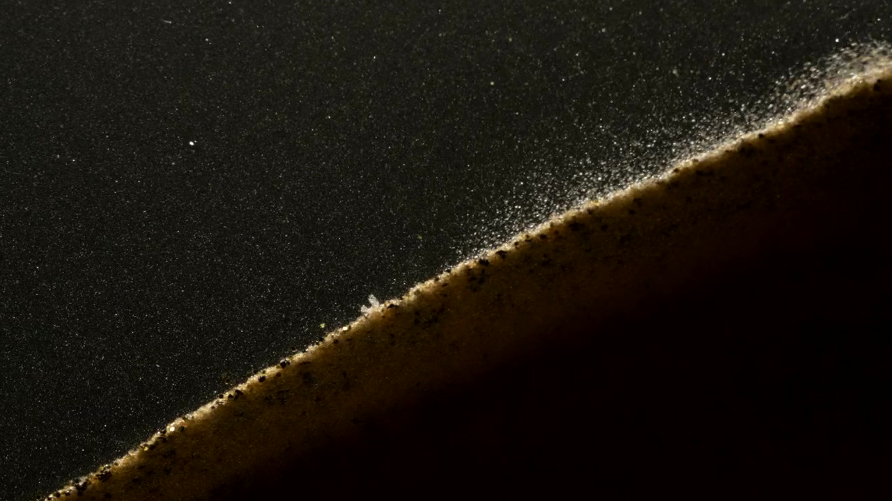 Small sand particles falling down the hill in abstract macro slow motion