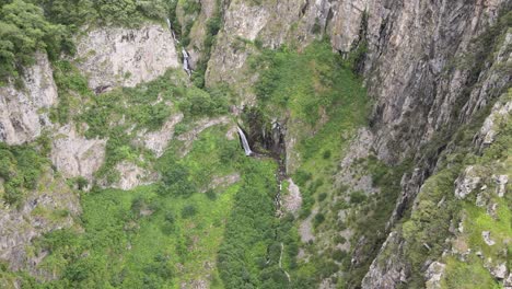 fotografía de paisaje de una cascada en medio de las montañas rocosas de las montañas caucásicas