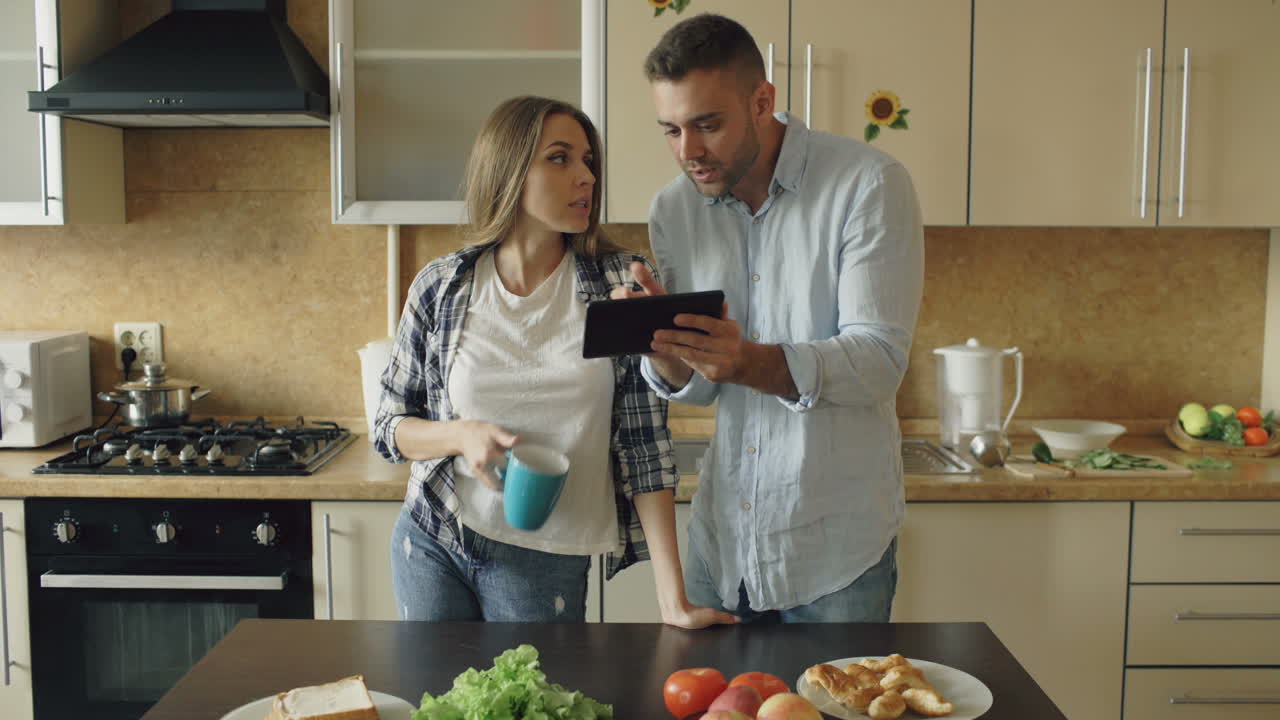 una pareja discutiendo en la cocina.