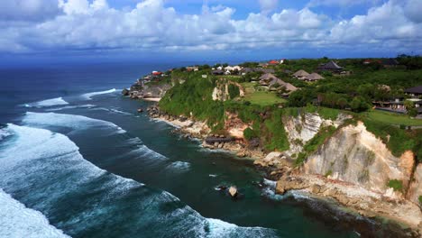 las olas del océano se acercan al acantilado costero de uluwatu en un día nublado en bali, indonesia