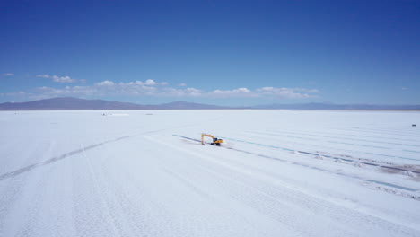 Excavator-extracts-minerals-at-salt-flats-in-Argentina,-aerial-push-in