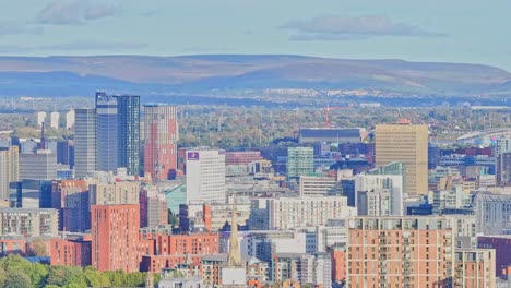 tomada lateral aérea que muestra el centro de la ciudad de manchester y las colinas en el fondo
