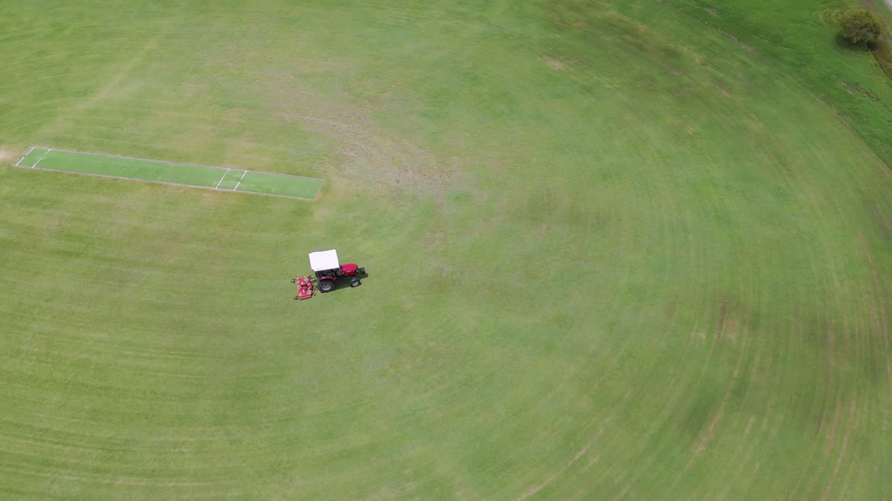 트랙터가 큰 스포츠 경기장을 효율적으로 고 있습니다.