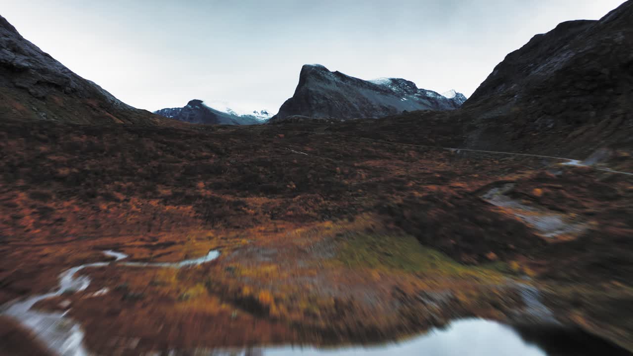 rápido vuelo hacia adelante por encima de los lagos, carretera serpenteante, y el valle de la tundra de otoño, su follaje vibrante contrasta bruscamente con el telón de fondo de la montaña helada