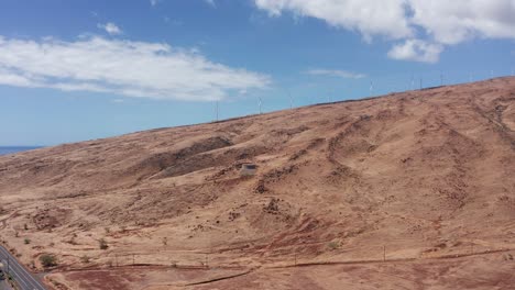 Aerial-wide-rising-shot-of-the-Kaheawa-Wind-Farm-along-the-coast-of-West-Maui,-Hawai'i