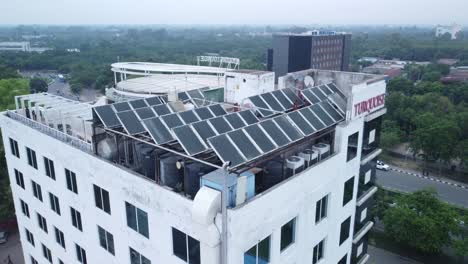 solar panels installed on commercial office building in suburban area of the indian metro city, punjab, drone shot