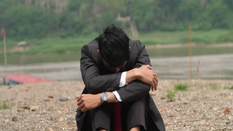 depressed businessman by the river