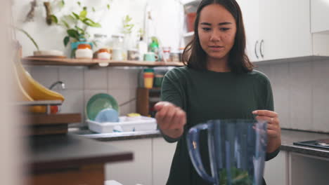 a young woman adding ingredients to a blender