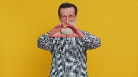 el anciano sonriente hace un gesto de corazón demuestra un signo de amor expresa buenos sentimientos y simpatía