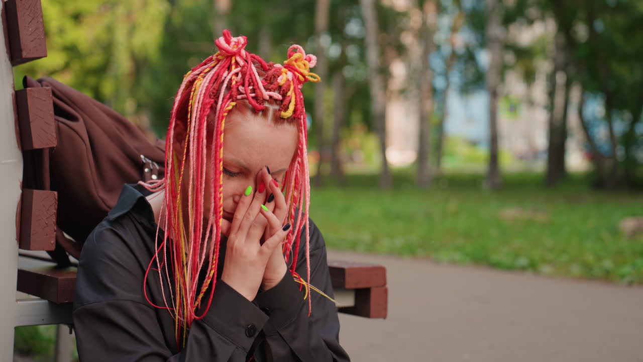 밖에서 속상해하는 젊은 여성, 공원 벤치에 앉아 슬퍼하는 여성, 야외 공원에서 정서적 고통을 느끼는 여성, 공원 환경의 야외에 앉아 슬픔에 압도된 젊은 여성