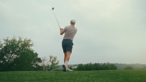 a male golfer drives the ball off the tee box as the sun flares through the frame. filmed from a low upward angle during golden hour, the clip captures motion, atmosphere, and dramatic natural light.