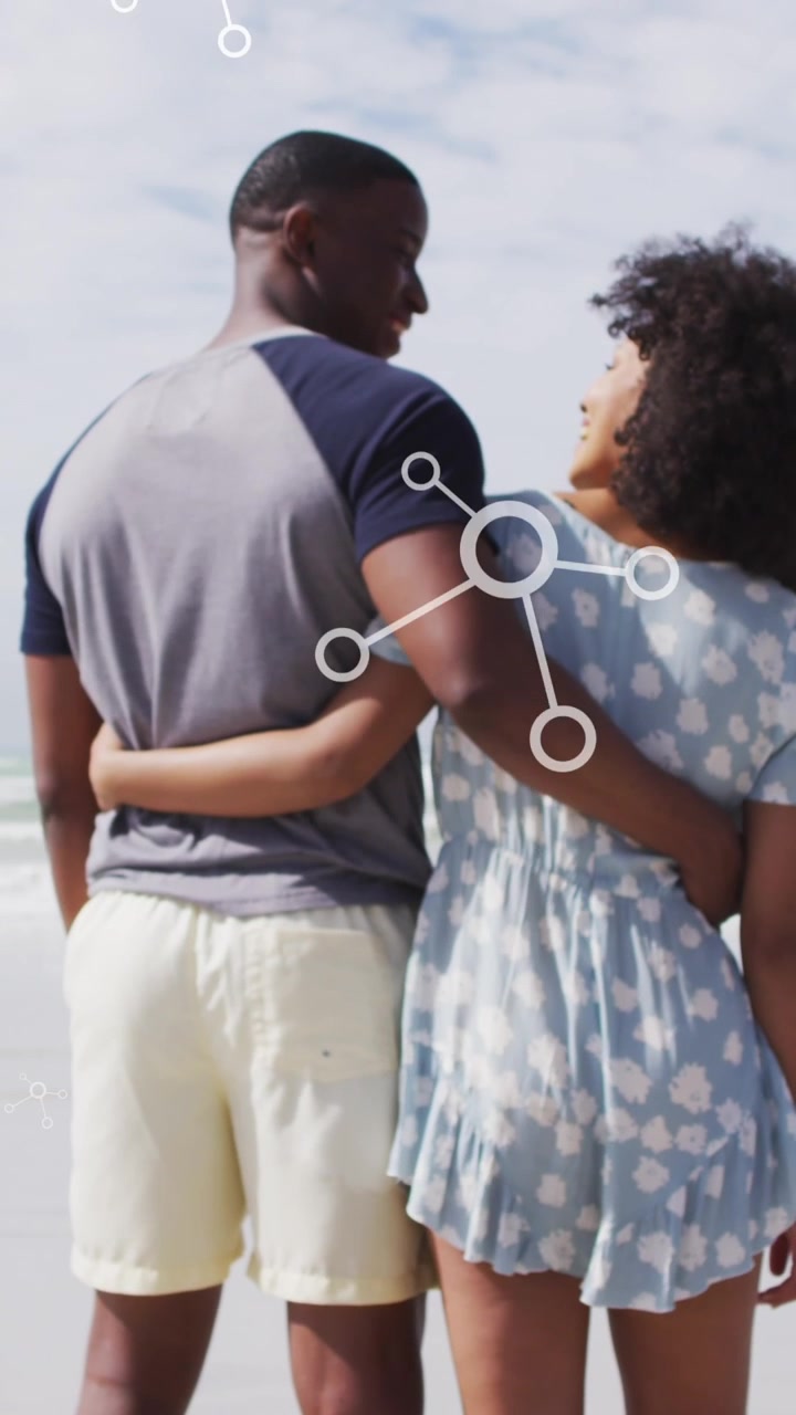 Animation of molecules over back view of african american couple embracing at beach