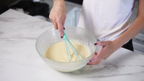 unrecognizable woman mixing ingredients in the the bowl using whisk. homemade cooking. fhd