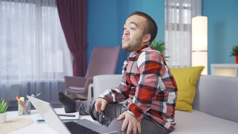 inteligente y feliz joven enano discapacitado trabajando en línea desde casa en la computadora.