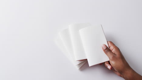 hand laying piece of paper on pieces of paper with copy space in slow motion