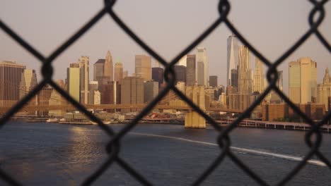 panning shot of golden skyline behind fence in new york city, usa - panoramic wide shot