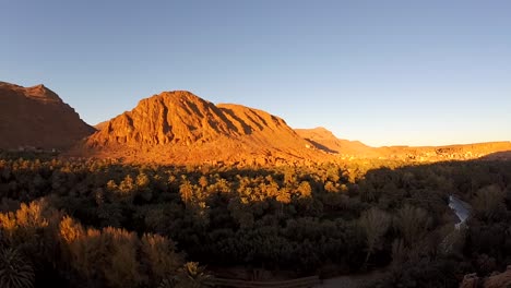 Panorámica-Izquierda-Lapso-De-Tiempo-De-La-Puesta-De-Sol-En-La-Ladera-De-La-Montaña-Del-Desfiladero-De-Todra-Con-Sombra-Proyectada-Gradualmente-Sobre-Las-Montañas