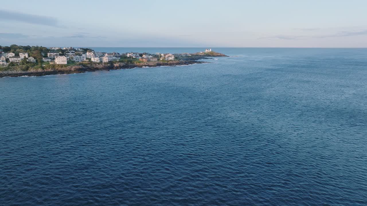 дронный снимок йорк-бич, штат мэн, летящий к мысу недик на закате