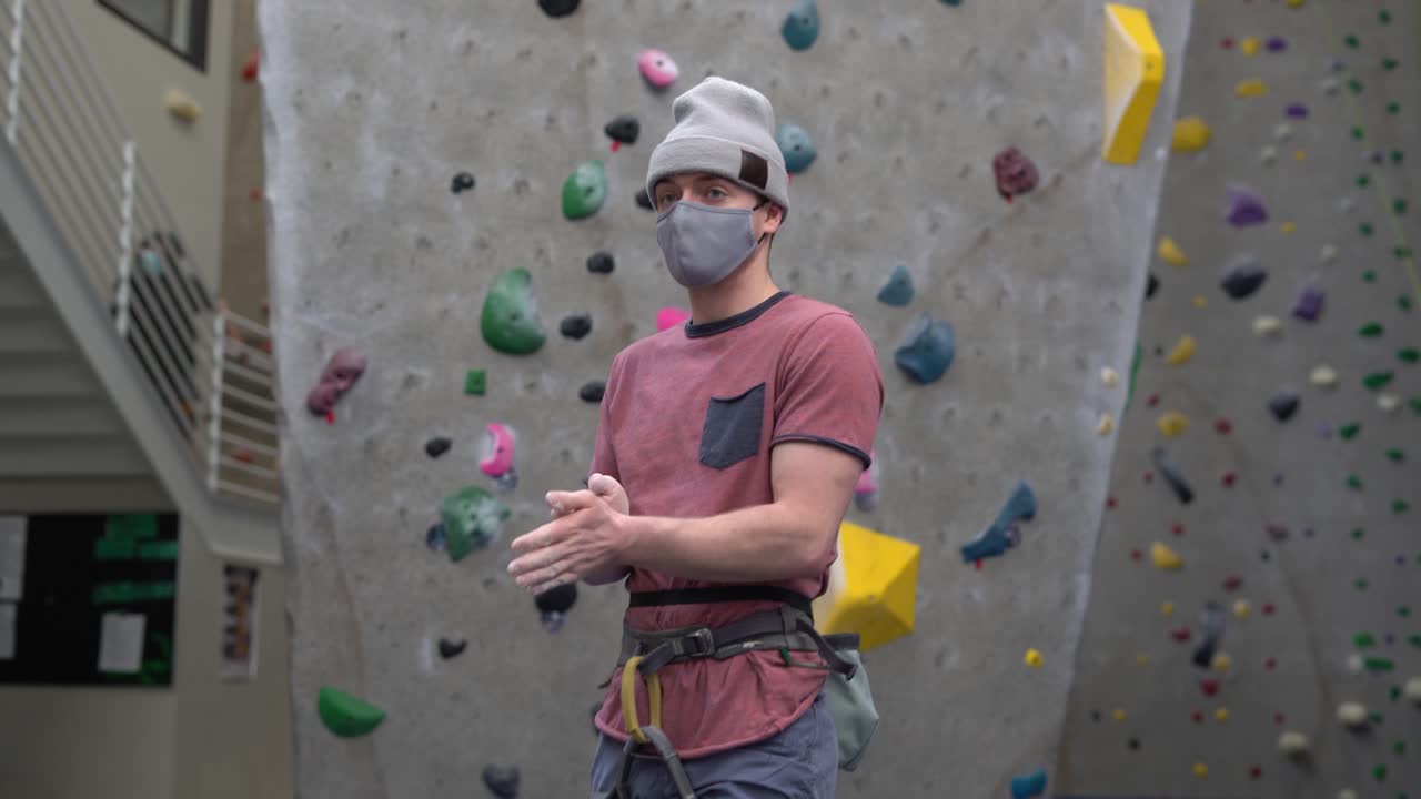 Man Preparing to Climb at Indoor Climbing Gym