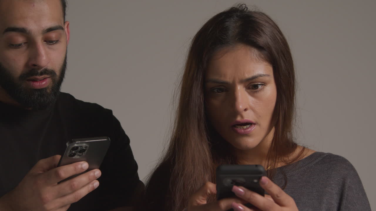 fotografía de estudio de un grupo de amigos con teléfonos móviles celebrando la ganancia de dinero contra un fondo gris 2