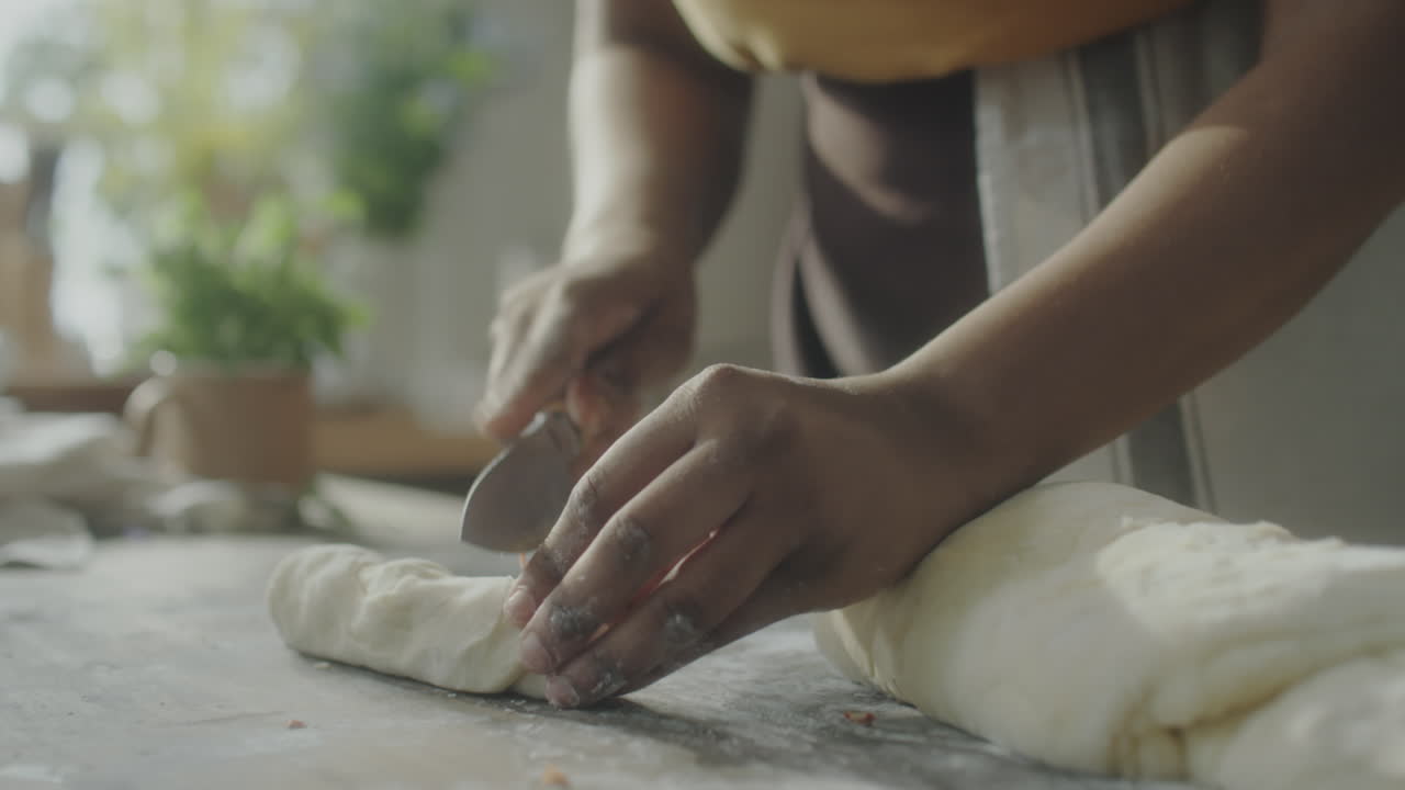 Hands rolling dough on a kitchen counter