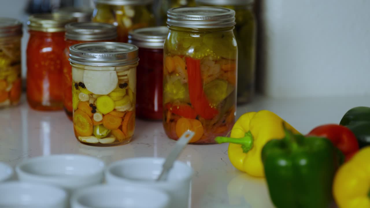Variety of canned foods in glass jars kept on kitchen table for winter consumption.