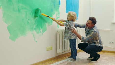 padre e hijo pintando una pared juntos