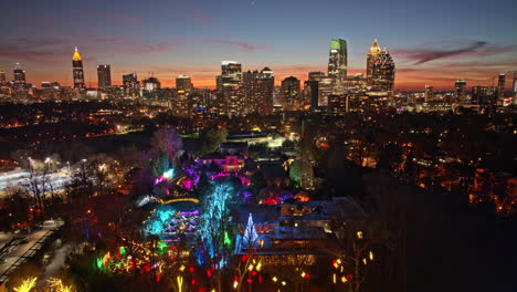 Atlanta-Aerial-V808-Hyperlapse-Flyover-Botanischer-Garten-Mit-Weihnachtslichtinstallation,-In-Richtung-Zentrales-Geschäftsviertel-Mit-Glänzenden-Hochhäusern---Aufgenommen-Mit-Mavic-3-Cine---Dezember-2021