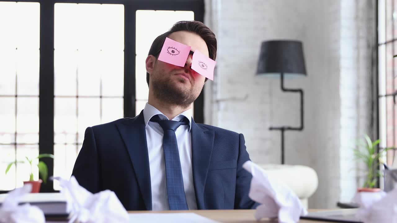 hombre de negocios gracioso durmiendo en el lugar de trabajo con notas adhesivas en la cara