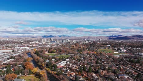 Drone-shot-pushing-in-on-Reno,-Nevada-with-clouds-and-blue-sky