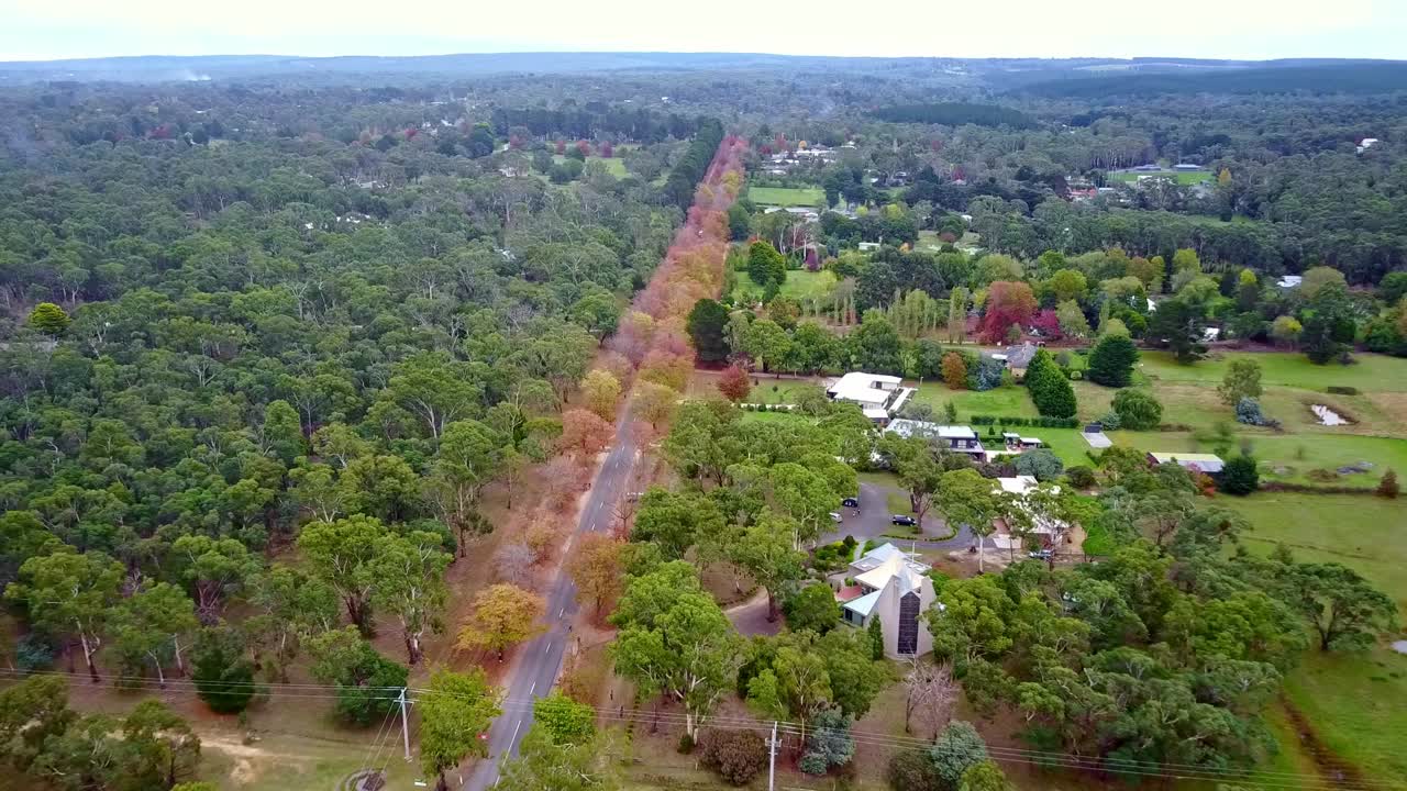 Reversing and rising drone footage of the Honour Avenue and rural properties at Macedon, Victoria, Australia