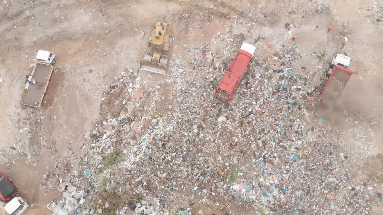 vehículos que limpian la basura apilada en un vertedero lleno de basura
