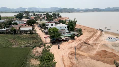 aerial view of a village by a river undergoing construction