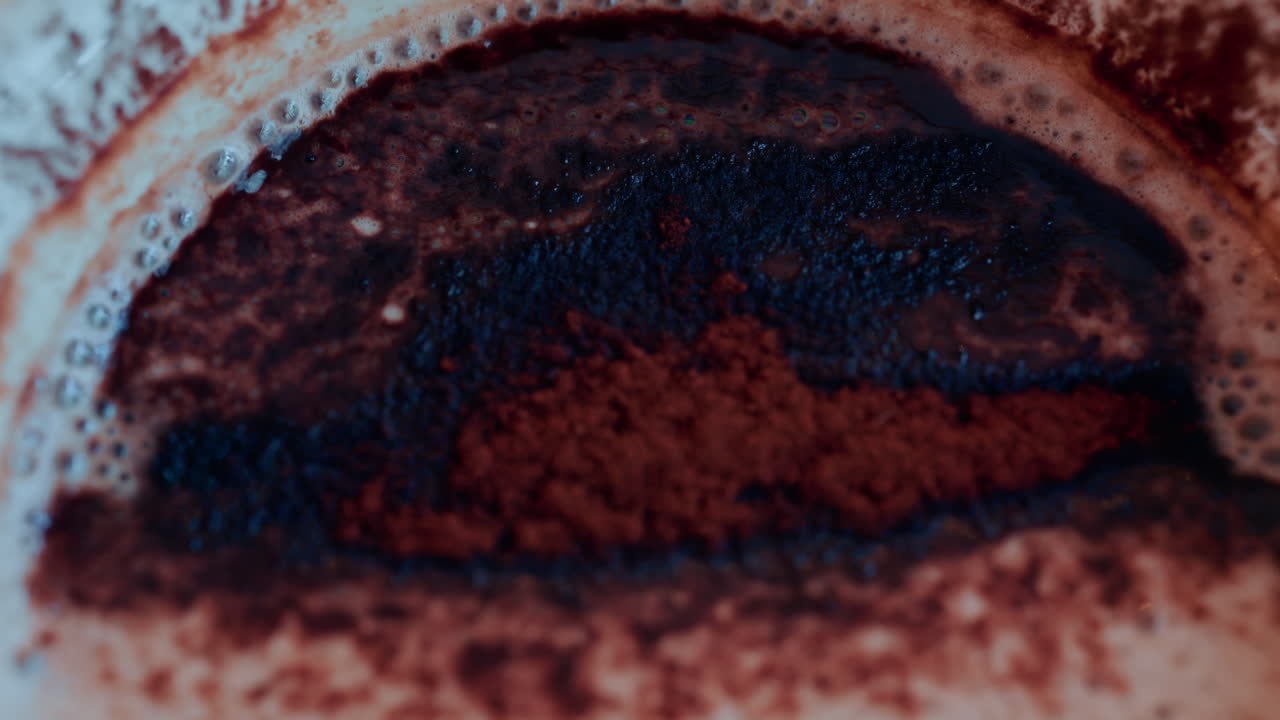 Close up of a rich hot chocolate or coffee surface sprinkled with cocoa powder