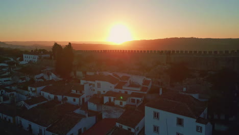 sunrise brightening medieval castle obidos towering over old town drone view.