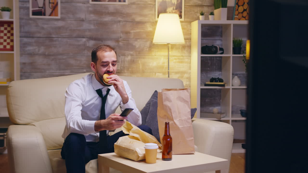 Caucasian businessman untying his tie sitting on couch