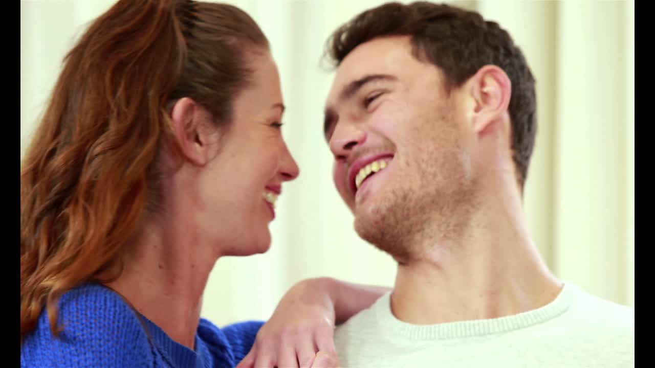 행복한 커플이 노트북을 사용하여 소파에 앉아 있습니다.