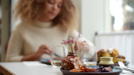 cerca de la comida mientras la mujer disfruta de la comida en el restaurante