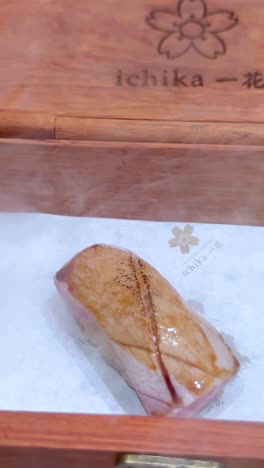 sushi servido con humo en una caja de madera