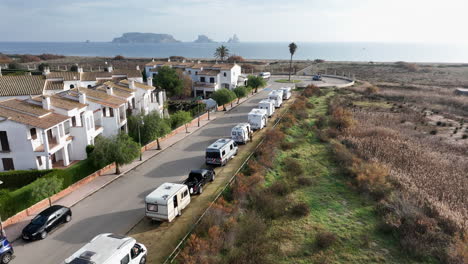 aerial flying over motorhomes parked on street next to beach, costa brava, spain