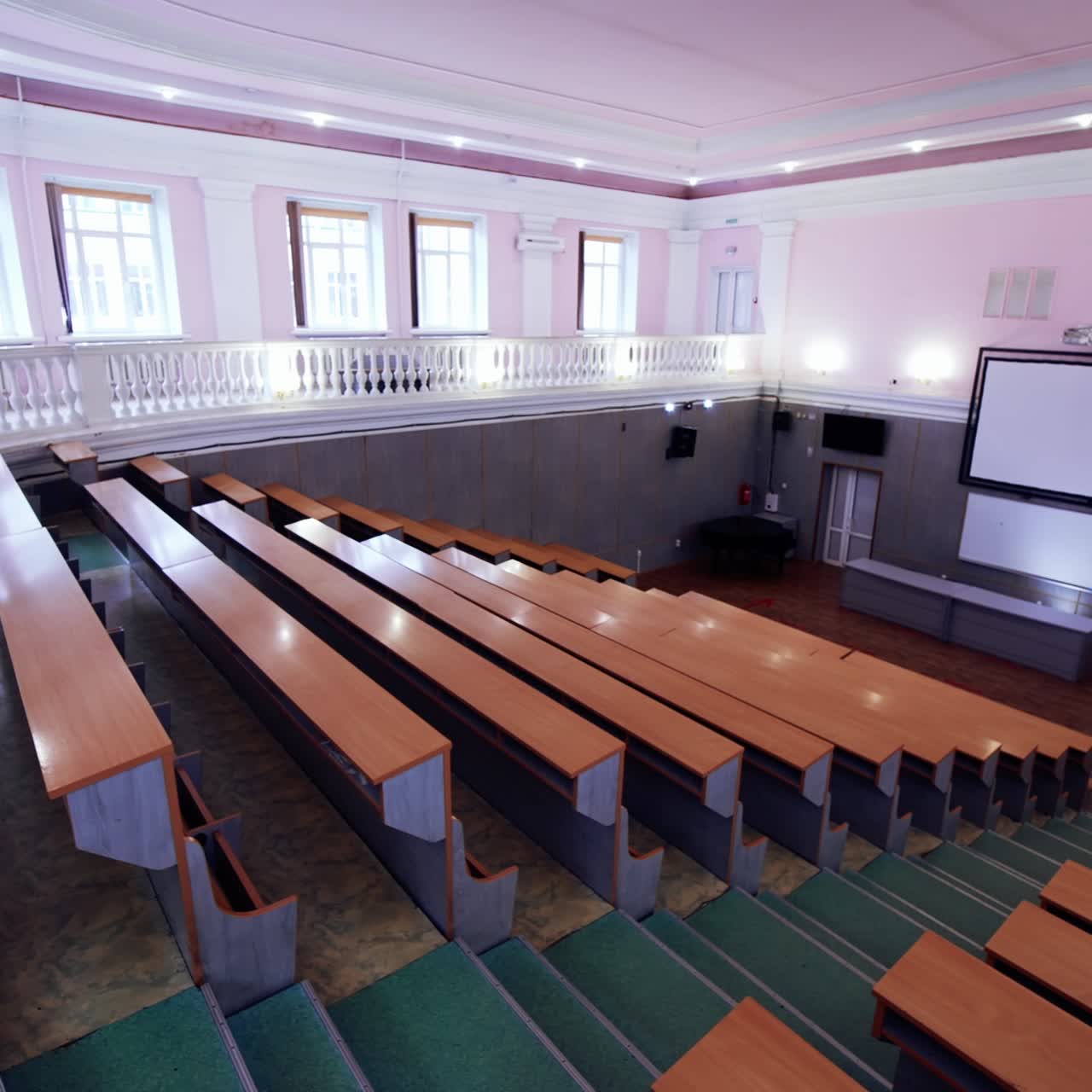 Contemporary auditorium for students. White board in the large classroom in front of wooden desks in the university