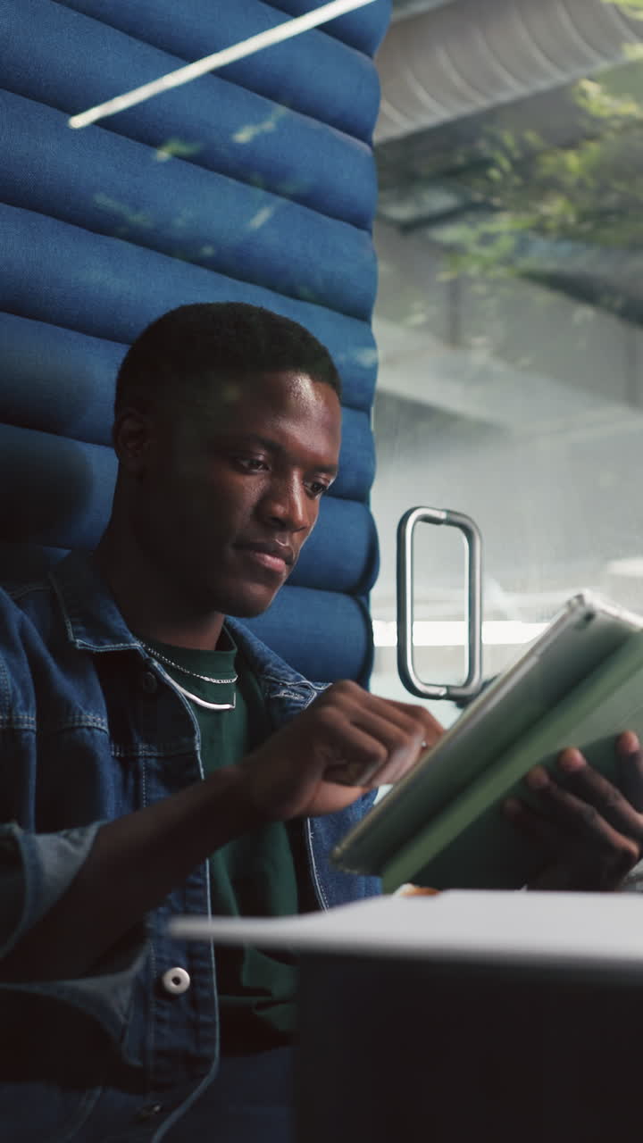Young Black Man Using Digital Tablet Indoors