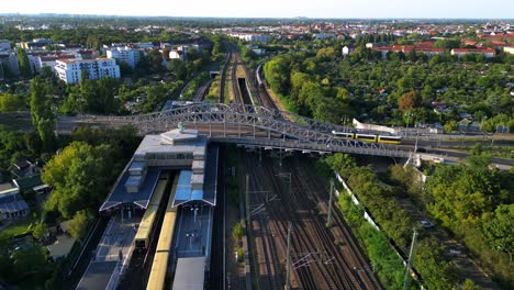 el tranvía y el tren corren por las vías en el puente del agente de la calle bornholmer en berlín, alemania.