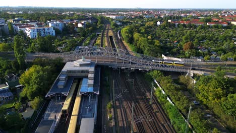 tramway and train runs on tracks at bornholmer street agent bridge in berlin, germany summer sunny day