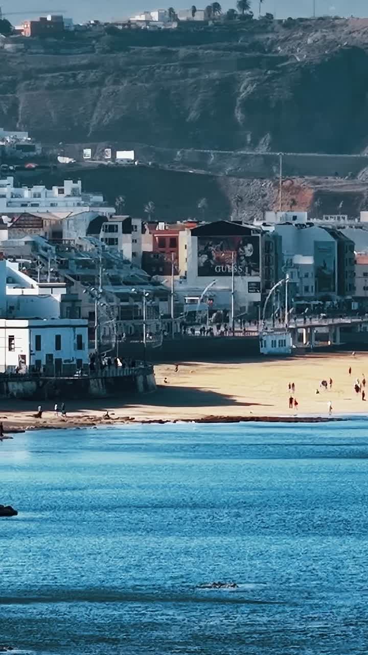 Vista costiera di Gran Canaria con persone che passeggiano lungo la spiaggia