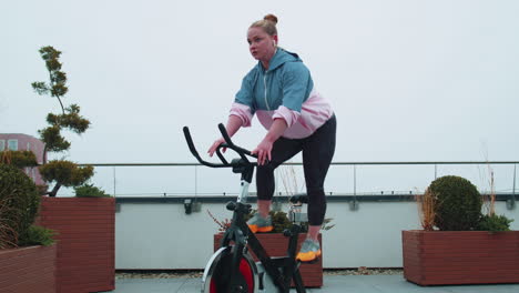 woman performs aerobic endurance training workout cardio routine on the simulators, cycle training