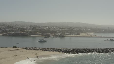 Beautiful-aerial-drone-of-California-coastal-beach-with-boats-in-the-harbor---Ungraded