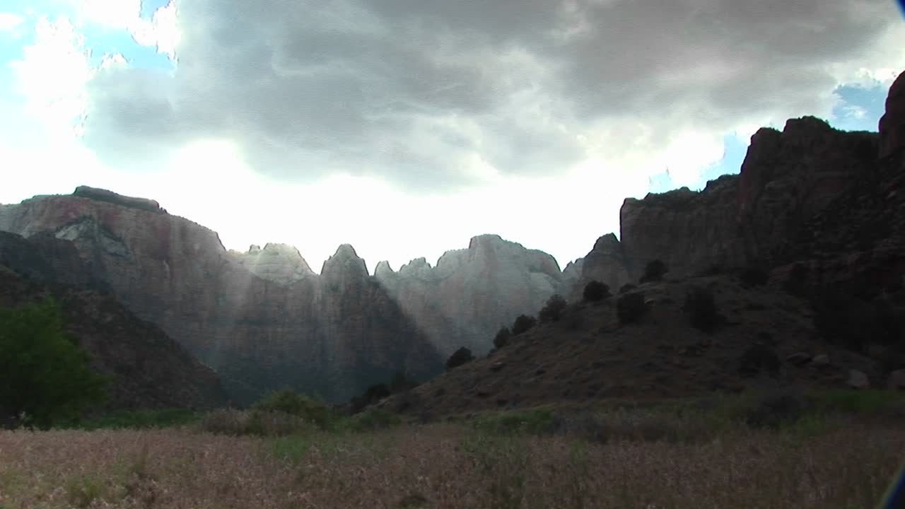 자이언 국립공원의 산봉우리 위로 필터링되는 긴 햇빛의 광선