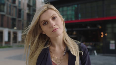 portrait-of-young-beautiful-blonde-woman-looking-up-pensive-turns-head-smiling-confident-at-camera