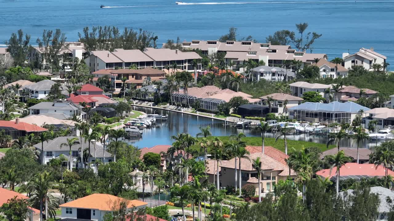 Upper class neighborhood of Cortez, Florida with gulf view. Sunny day with palm trees and parking boats at pier jetty. United States with houses and homes in Florida.
